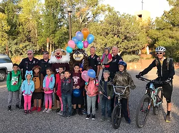 Group of kids smiling with mascots and police on their way to school