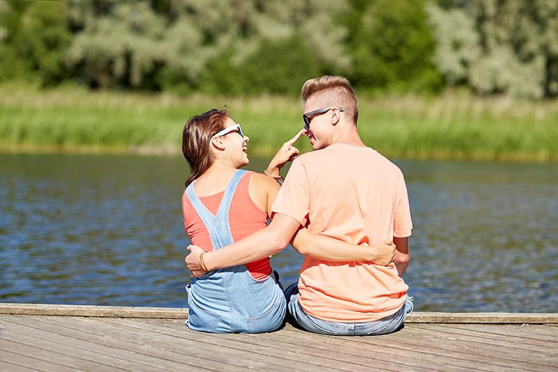 happy teenage couple hugging on river summer berth