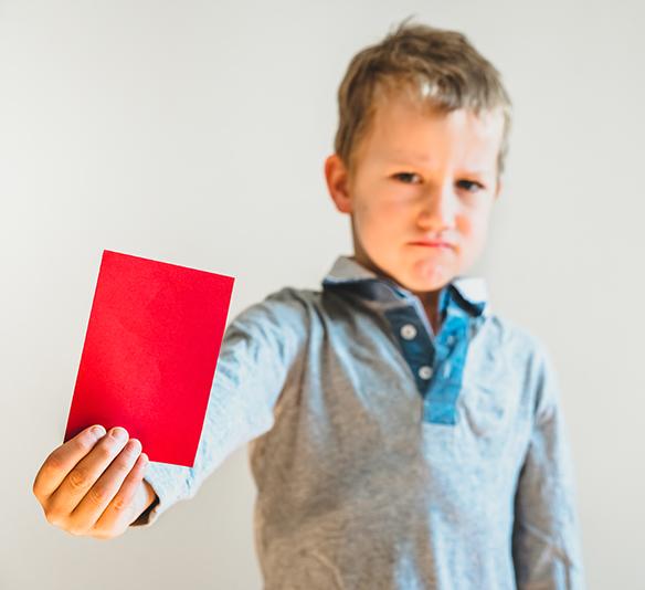 Scared child with red anti bullying card